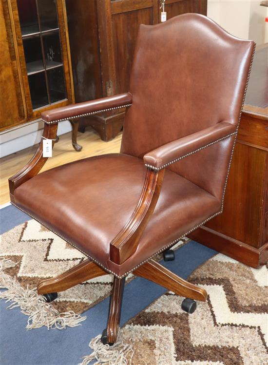 A reproduction brown leather desk chair